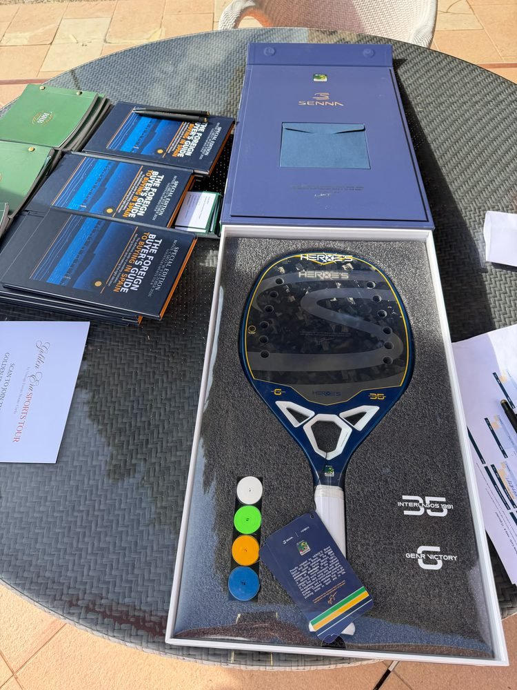 Copies of the book beside a boxed racquet gift set on a table